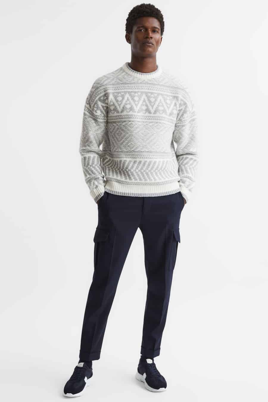 Men's navy cargo pants, fair isle sweater and suede sneakers outfit