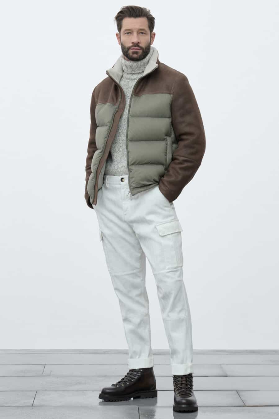 Men's white cargo pants, light grey roll neck jumper, puffer jacket and leather hiking boots outfit