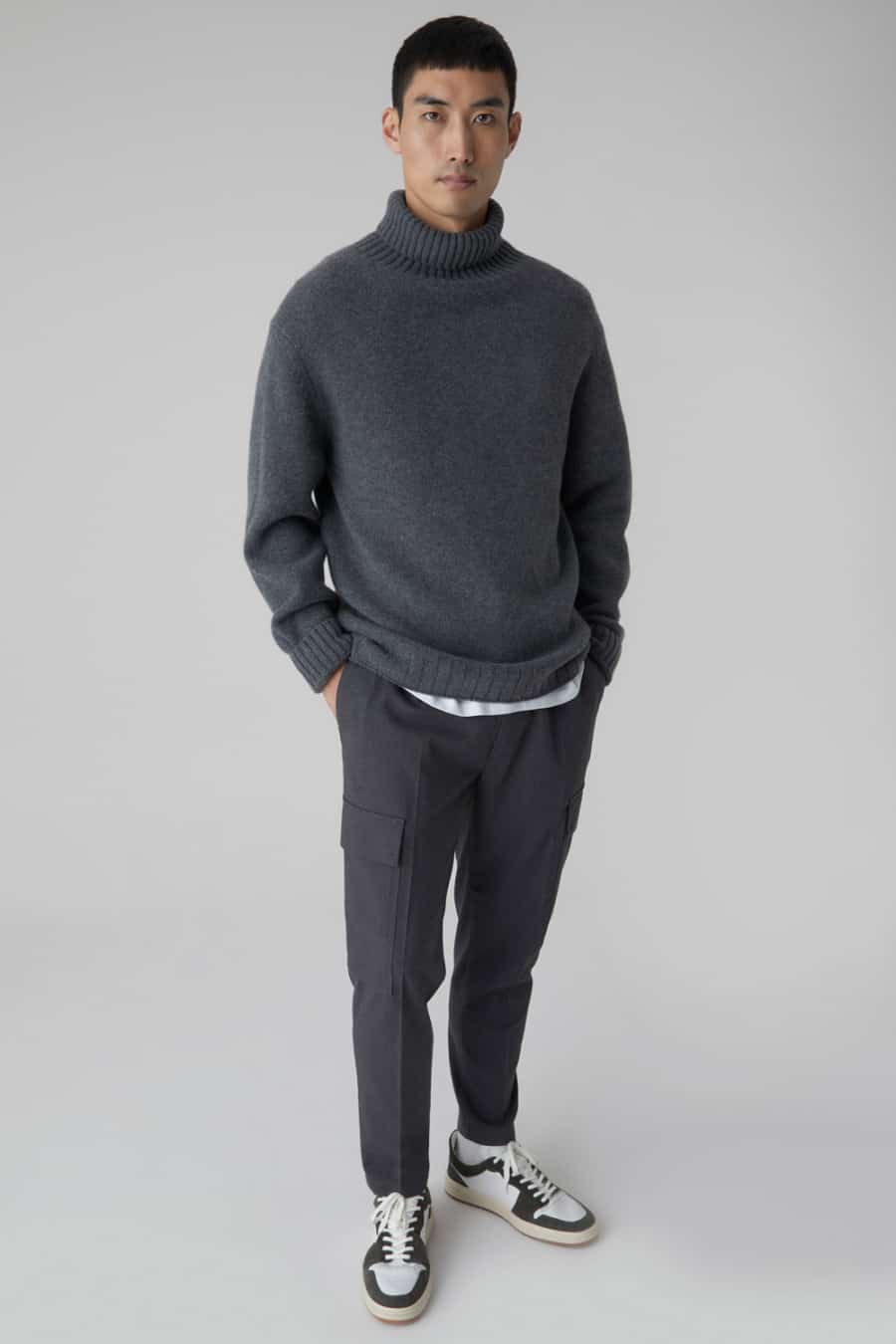 Men's grey wool cargo pants, chunky grey roll neck and running sneakers outfit