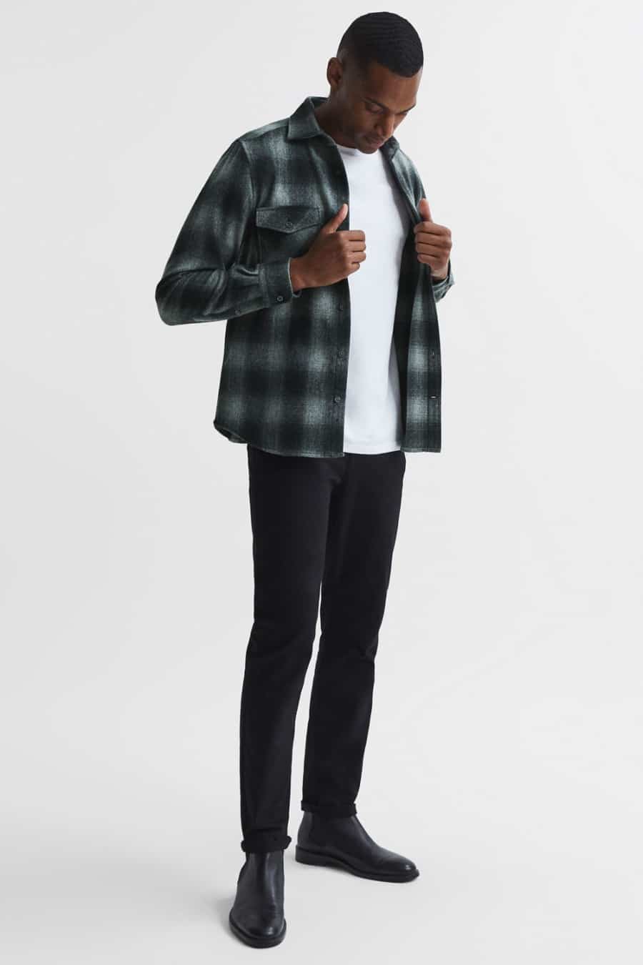 Men's black jeans, white T-shirt, check flannel shirt and black Chelsea boots outfit
