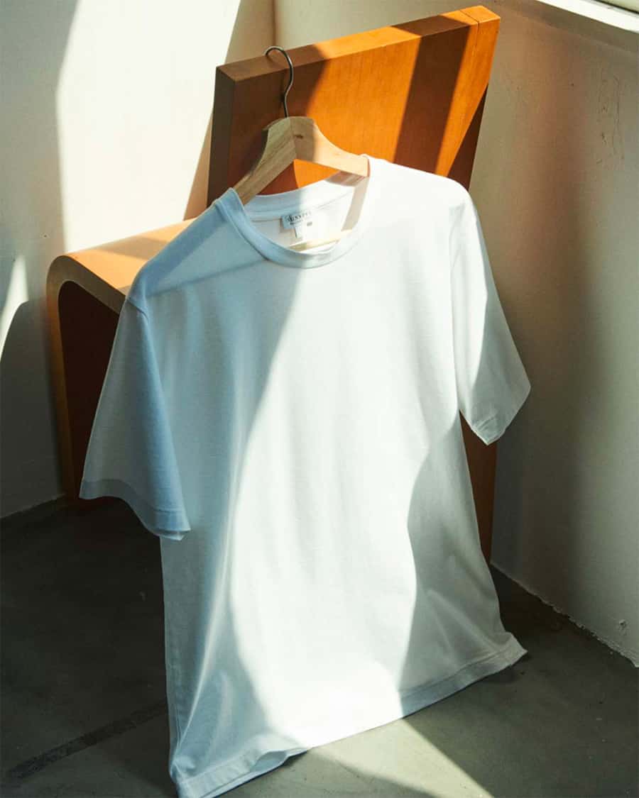 High end white T-shirt on a hanger on the back of a chair