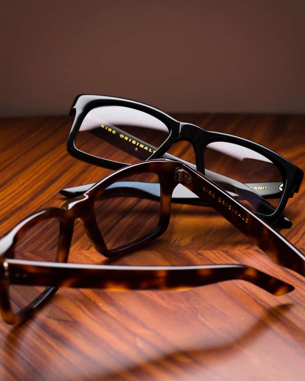 Two pairs of Kirk Originals spectacles in tortoiseshell and black acetate frames
