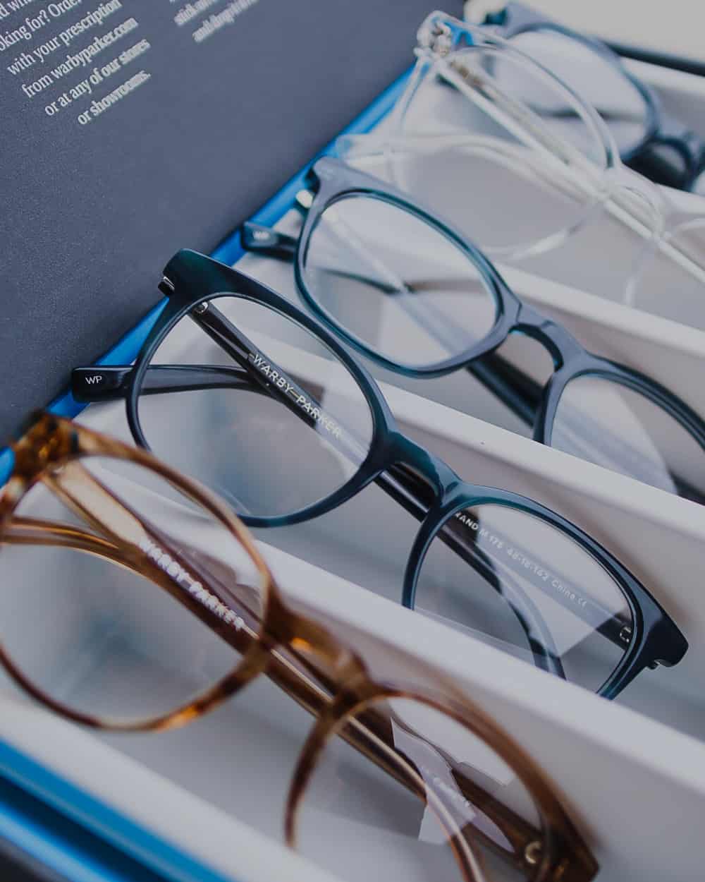 Selection of men's Warby Parker round lens spectacles in tortoiseshell, blue and clear acetate