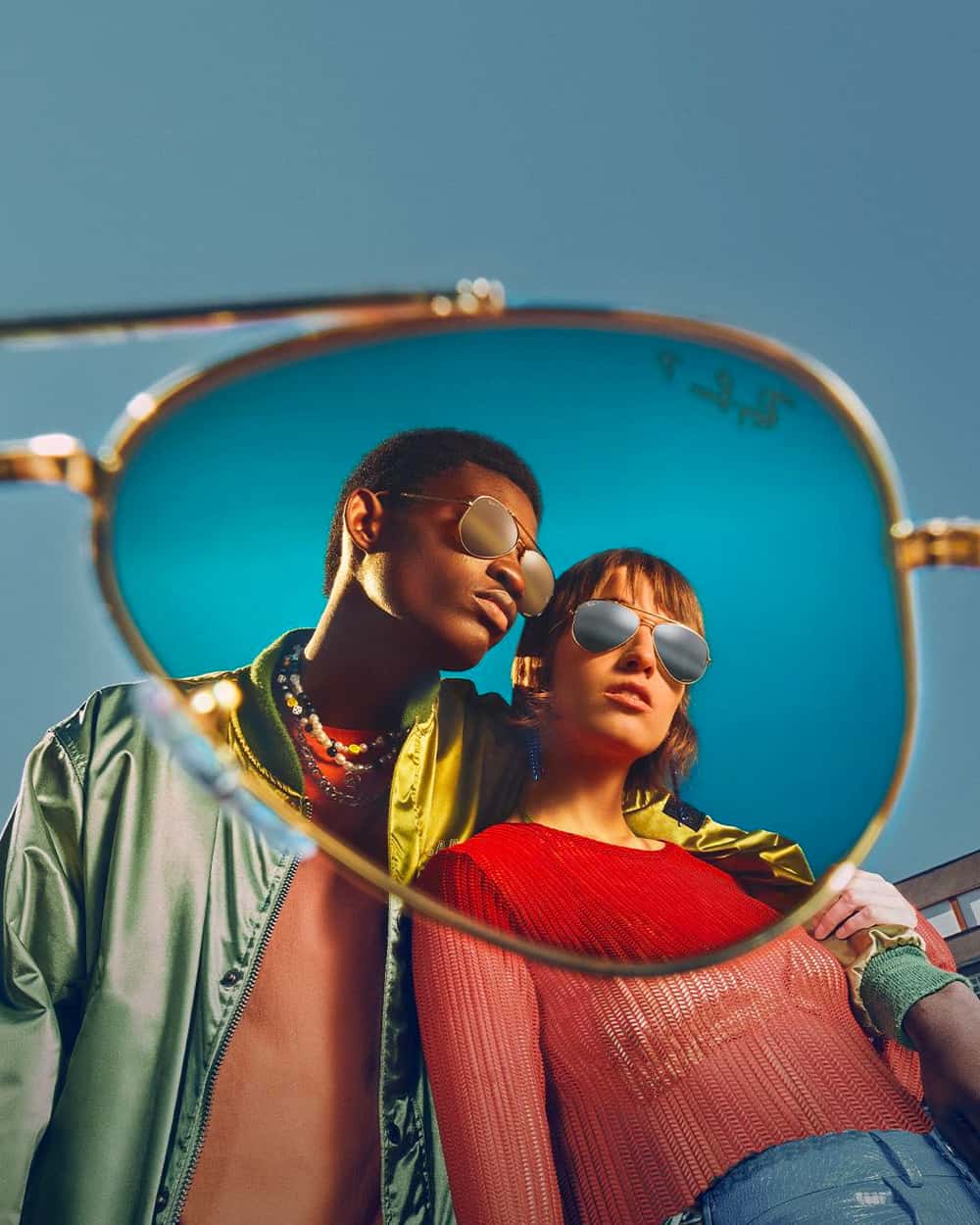Man and woman wearing mirrored lens Ray-Ban sunglasses