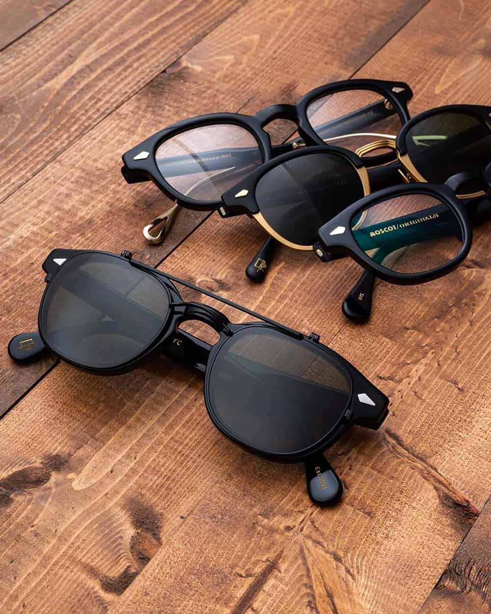 A selection of men's black frame MOSCOT spectacles and sunglasses