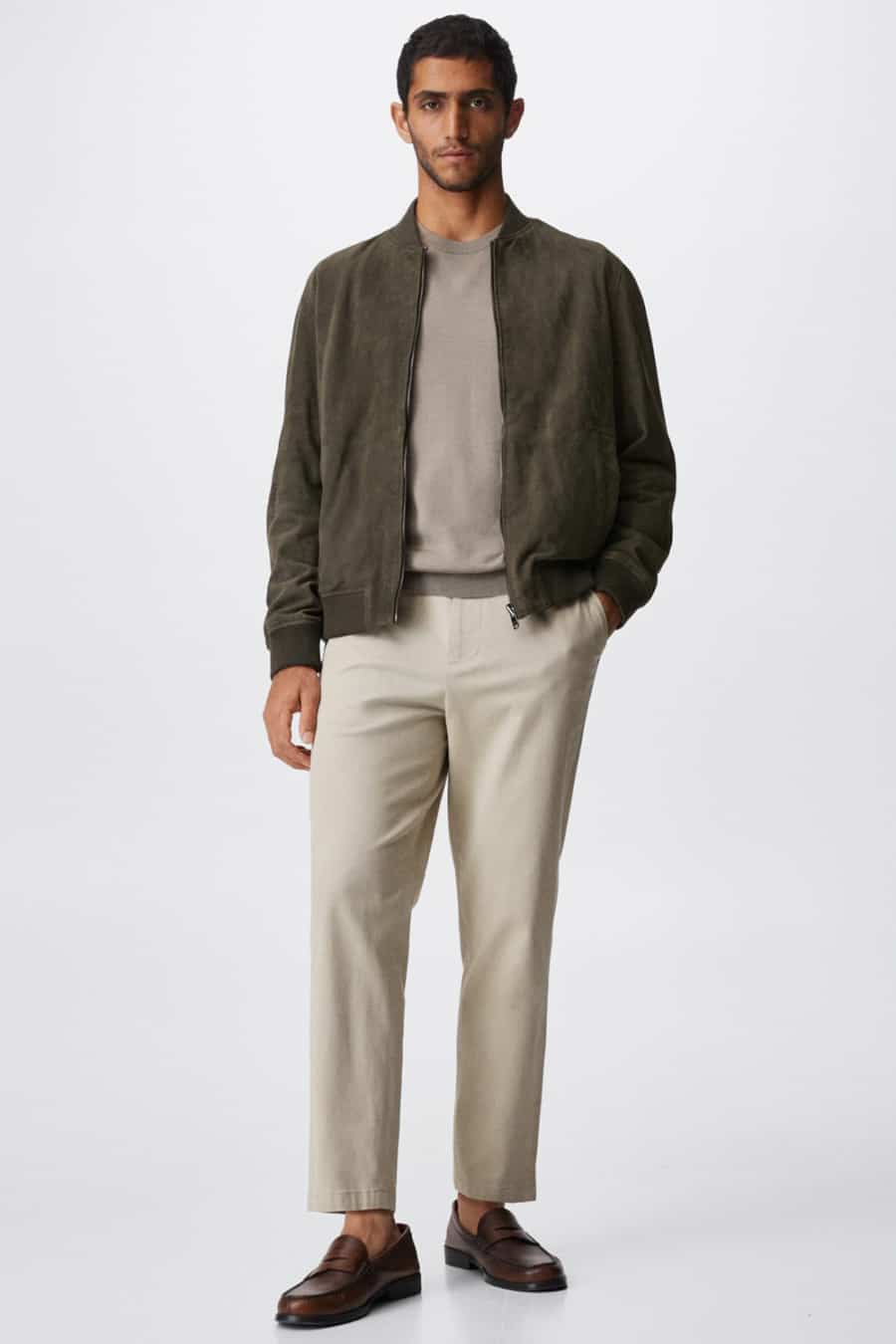 Men's beige trousers, taupe sweater, khaki green suede bomber jacket and brown penny loafers outfit
