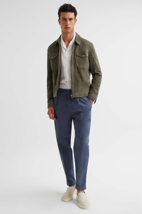 Men's blue pleated trousers, white Cuban collar shirt, green suede blouson and suede loafers outfit