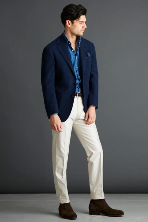 Men's white trousers, blue shirt, navy blazer and brown Chelsea boots outfit