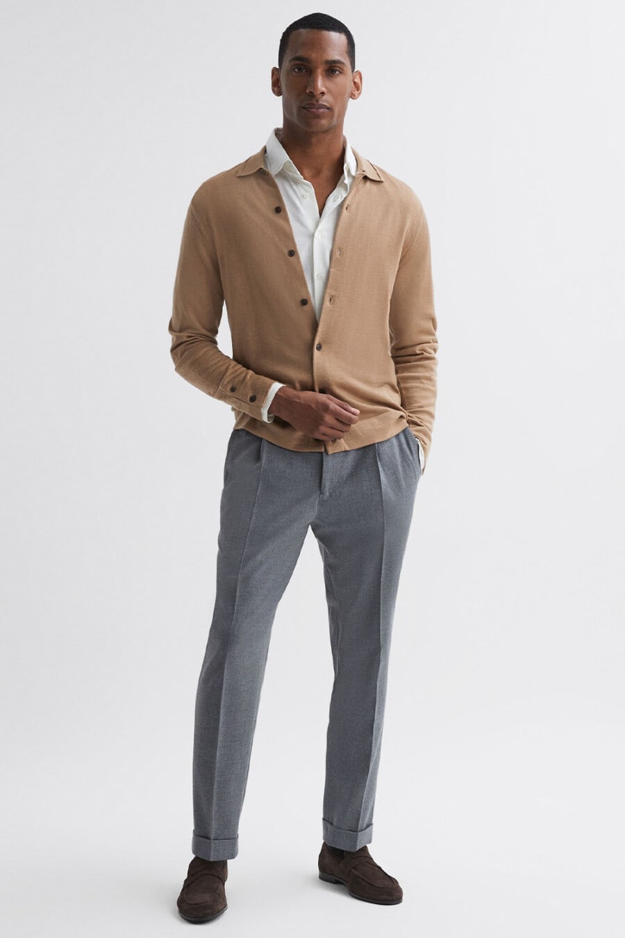 Men's grey turn-up tailored pants, white dress shirt, tan cardigan and brown suede penny loafers business casual outfit