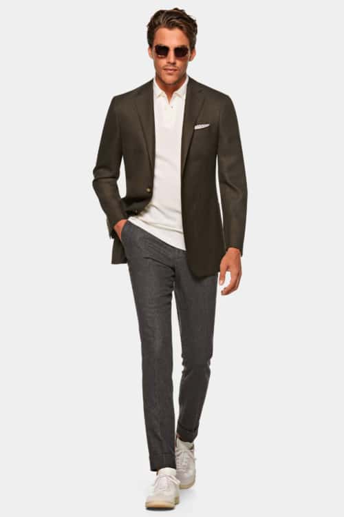 Men's grey trousers, white polo shirt, brown blazer and sneakers outfit