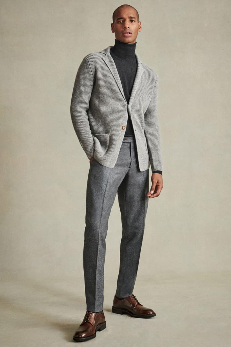 Men's grey dress pants, charcoal turtleneck, light grey knitted blazer and brown leather shoes outfit