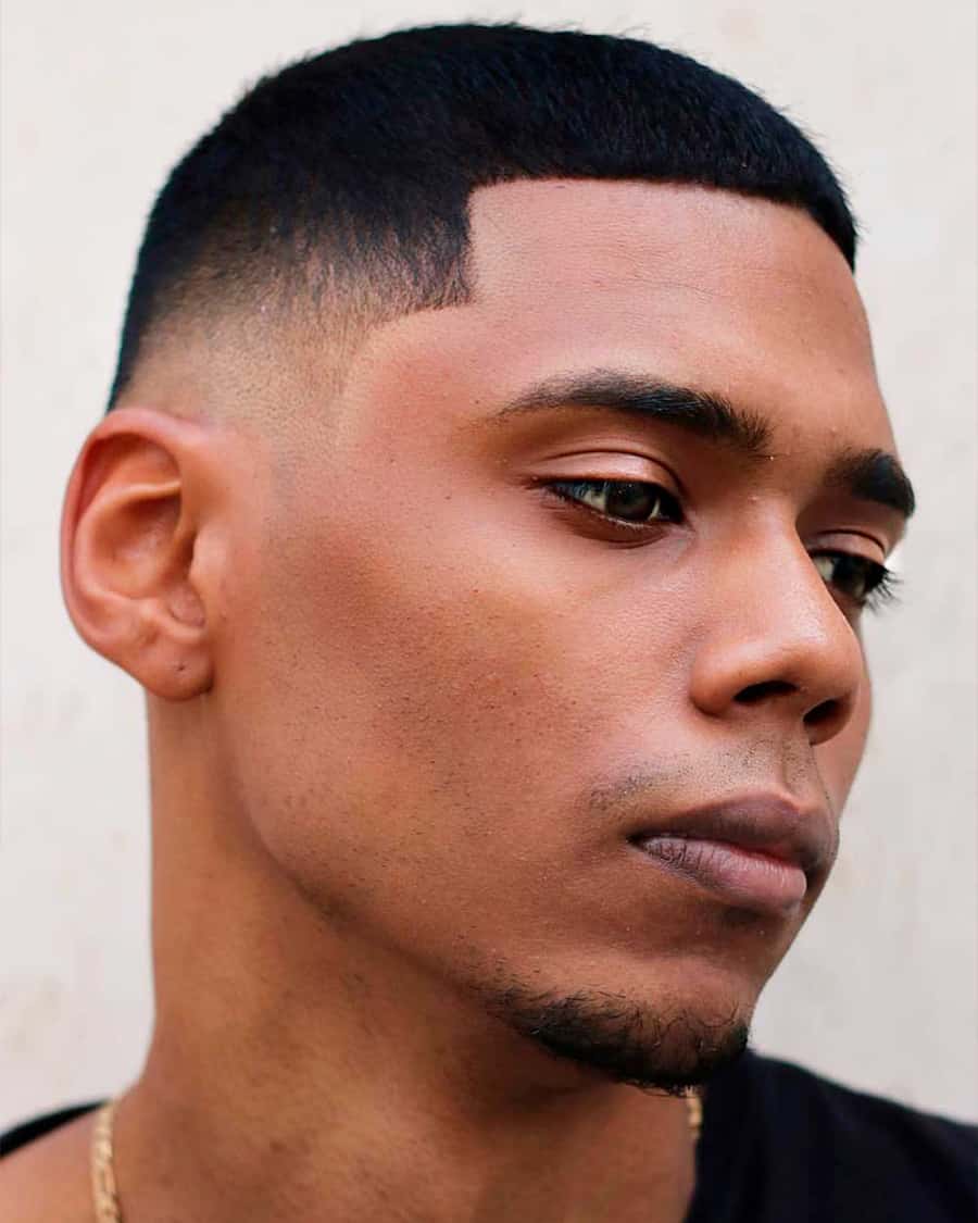 Black man with a buzz cut fade, sharp line up and skin fade