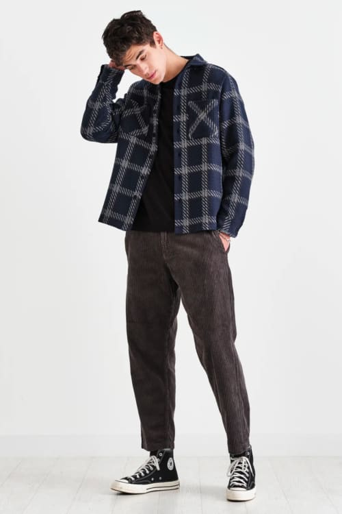 Men's corduroy trousers, black T-shirt, flannel check overshirt and black Converse high-tops outfit