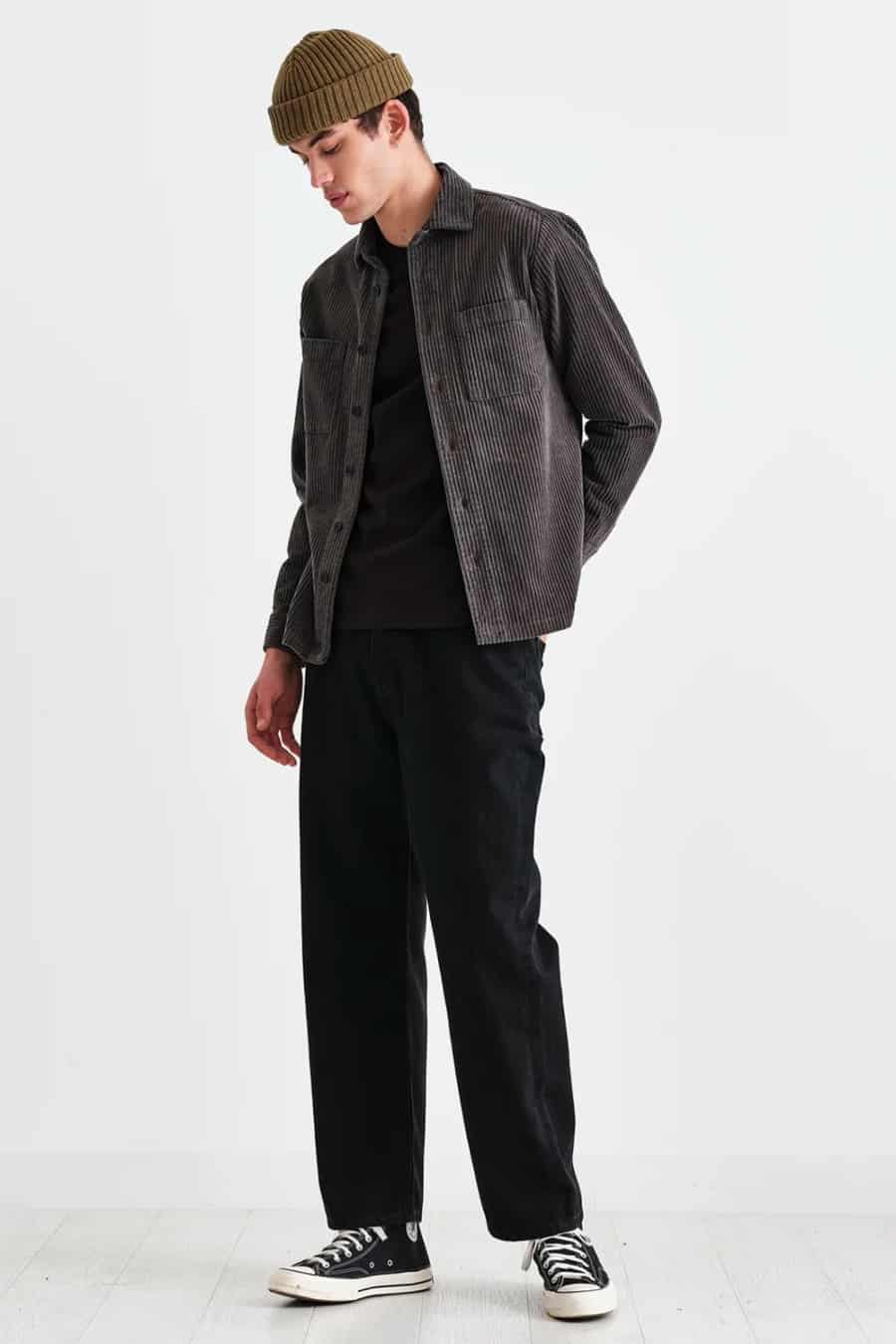 Men's black trousers, black T-shirt, corduroy overshirt, beanie and high-top sneakers outfit