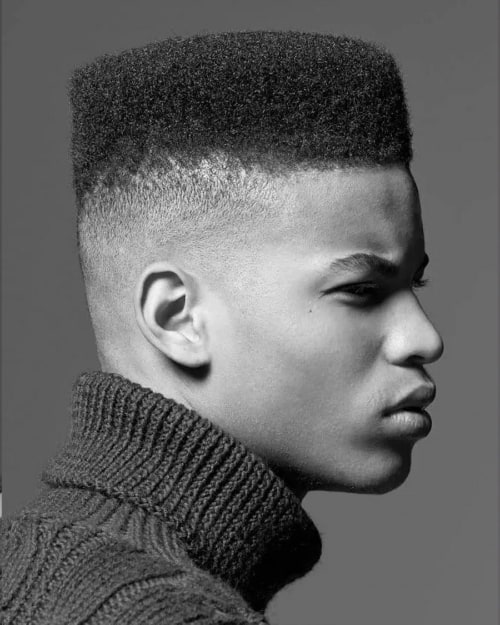 Black man with a high top/flat top and fade haircut
