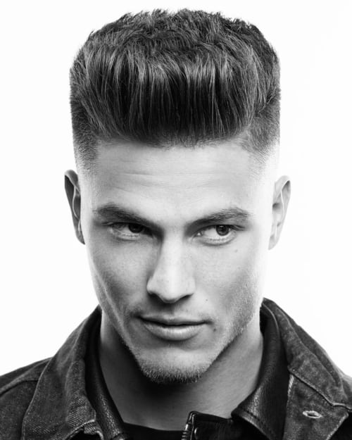 Man with standing up straight hair which looks like a flat top haircut
