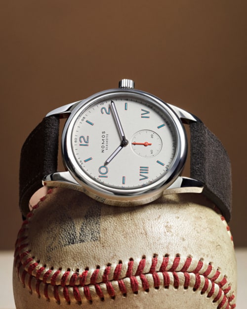NOMOS Club Reference 701 watch on top of a baseball