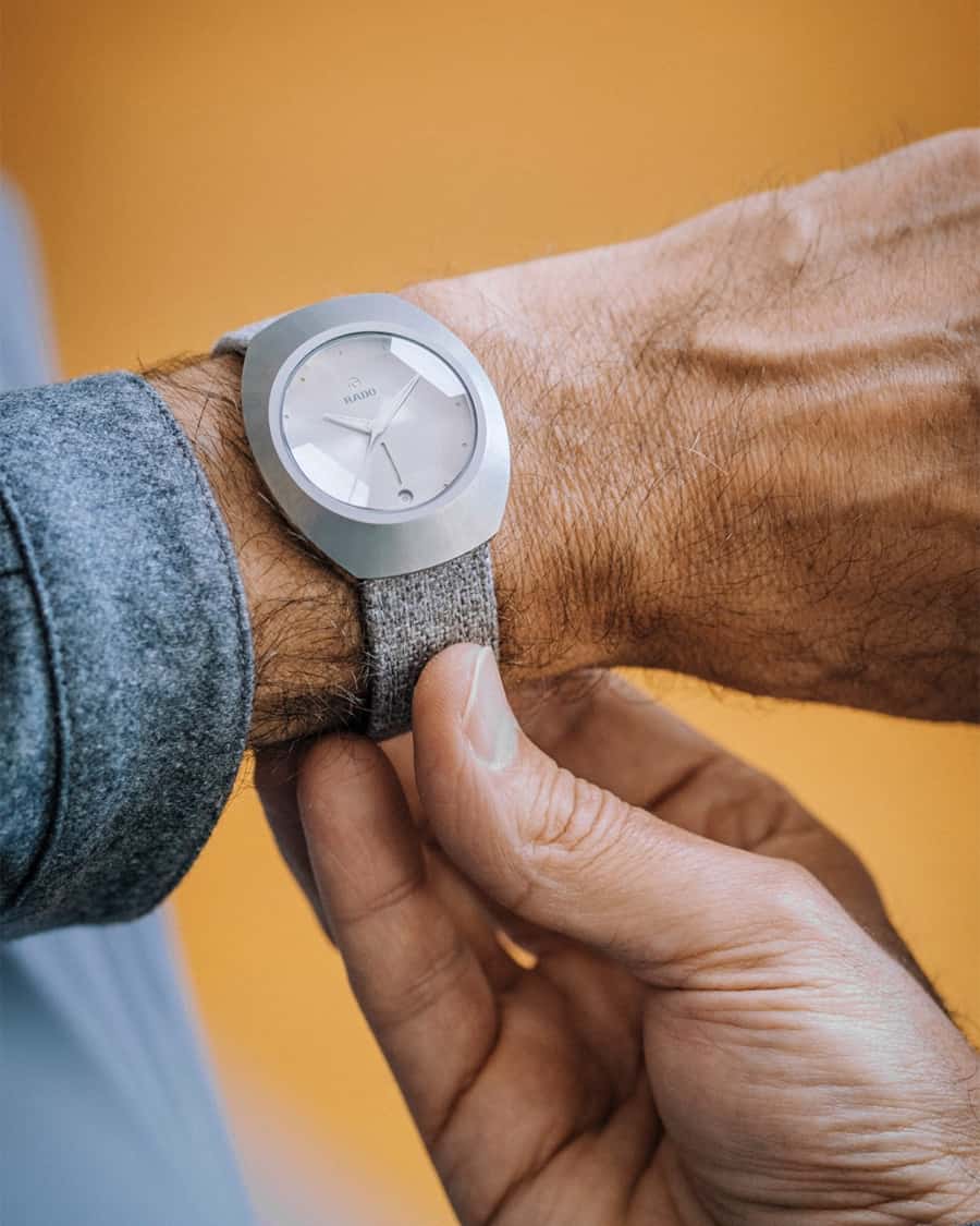 Man wearing luxury RADO watch on his wrist with a grey shirt