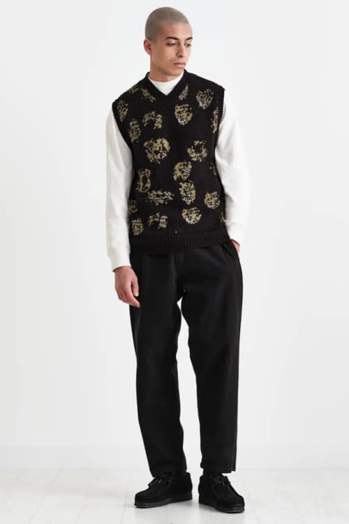 Men's black trousers, white long sleeve top, black sweater vest and black suede shoes outfit