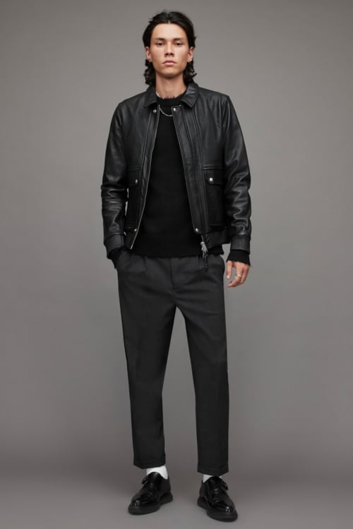 Men's black wide leg chinos, black sweater, black leather jacket and black chunky shoes outfit
