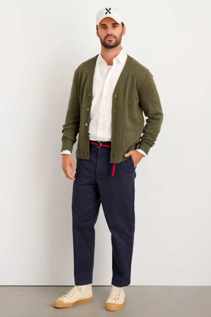 Men's navy chinos, white shirt, green cardigan and white high-top sneakers outfit