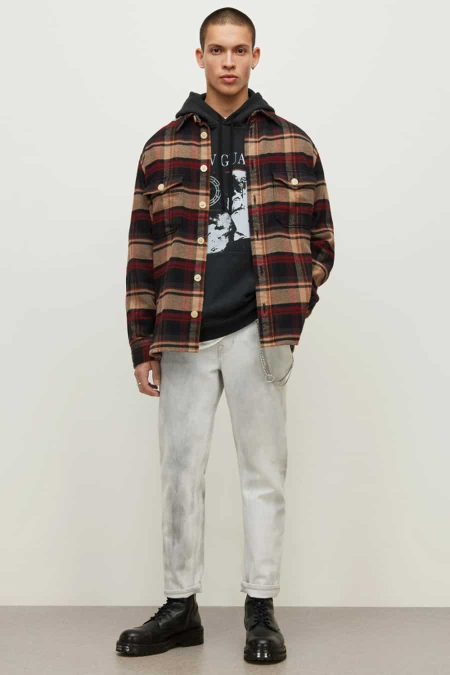 Men's washed grey jeans, black printed hoodie, red and brown check flannel shirt and black boots outfit