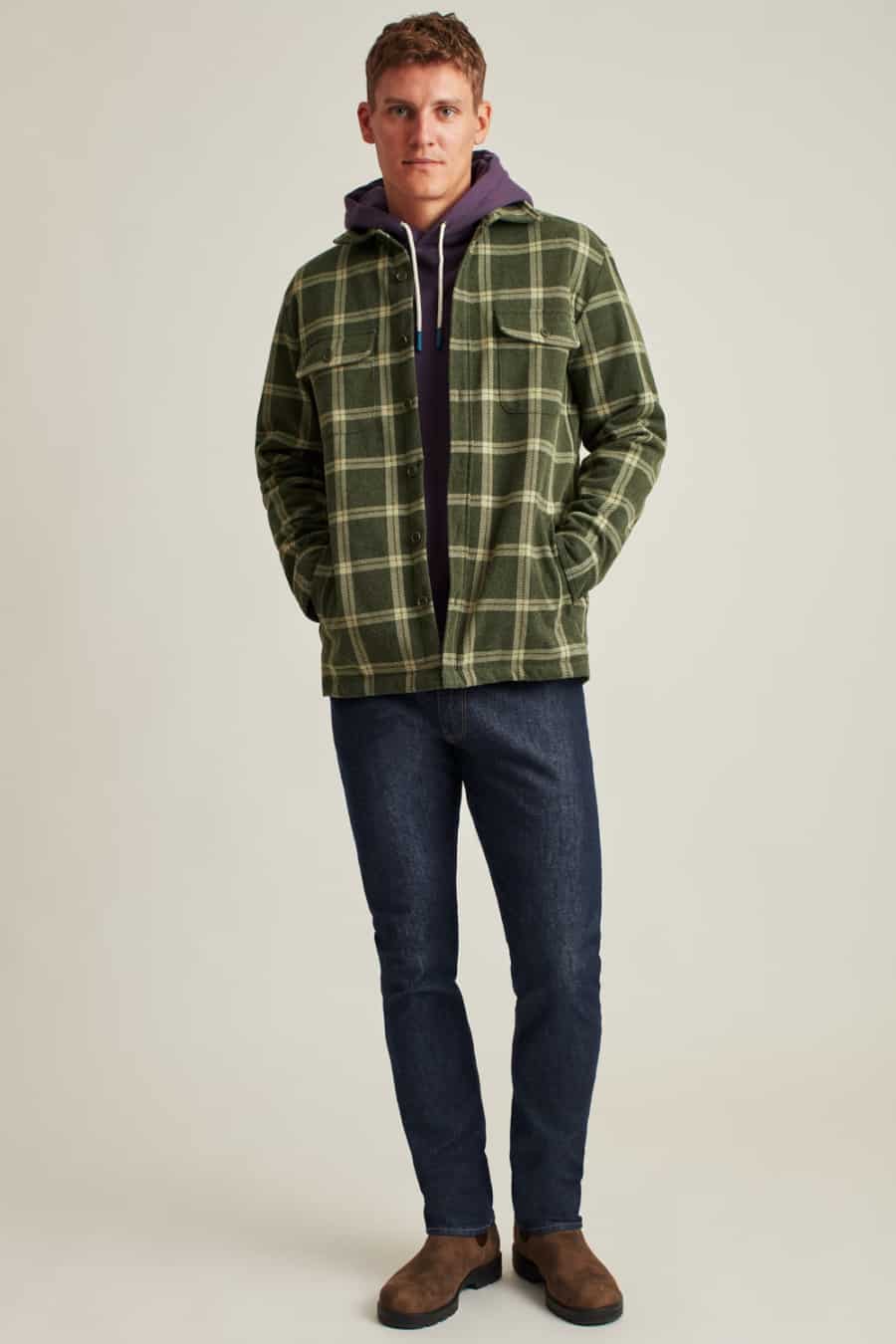 Men's dark jeans, purple hoodie, green and yellow flannel shirt and brown boots outfit