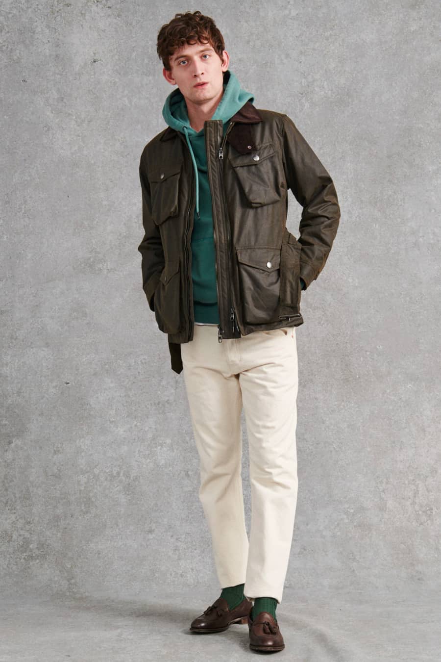 Men's white jeans, green hoodie, brown waxed jacket and brown tassel loafers outfit