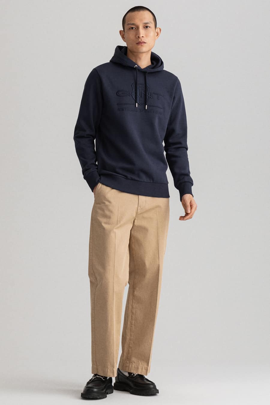 Men's loose khaki chino pants, navy hoodie and black leather loafers outfit