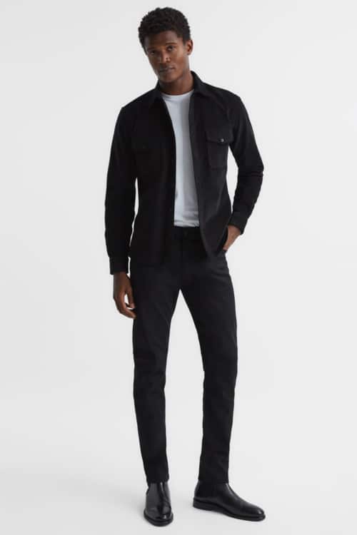 Men's black jeans, black Chelsea boots, white T-shirt and black overshirt outfit
