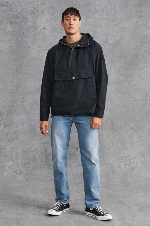 Men's light wash jeans, navy pullover technical jacket and black canvas sneakers outfit