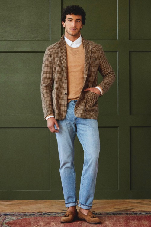 Men's light wash jeans, white shirt, tan sweater, tweed check blazer and suede loafers outfit