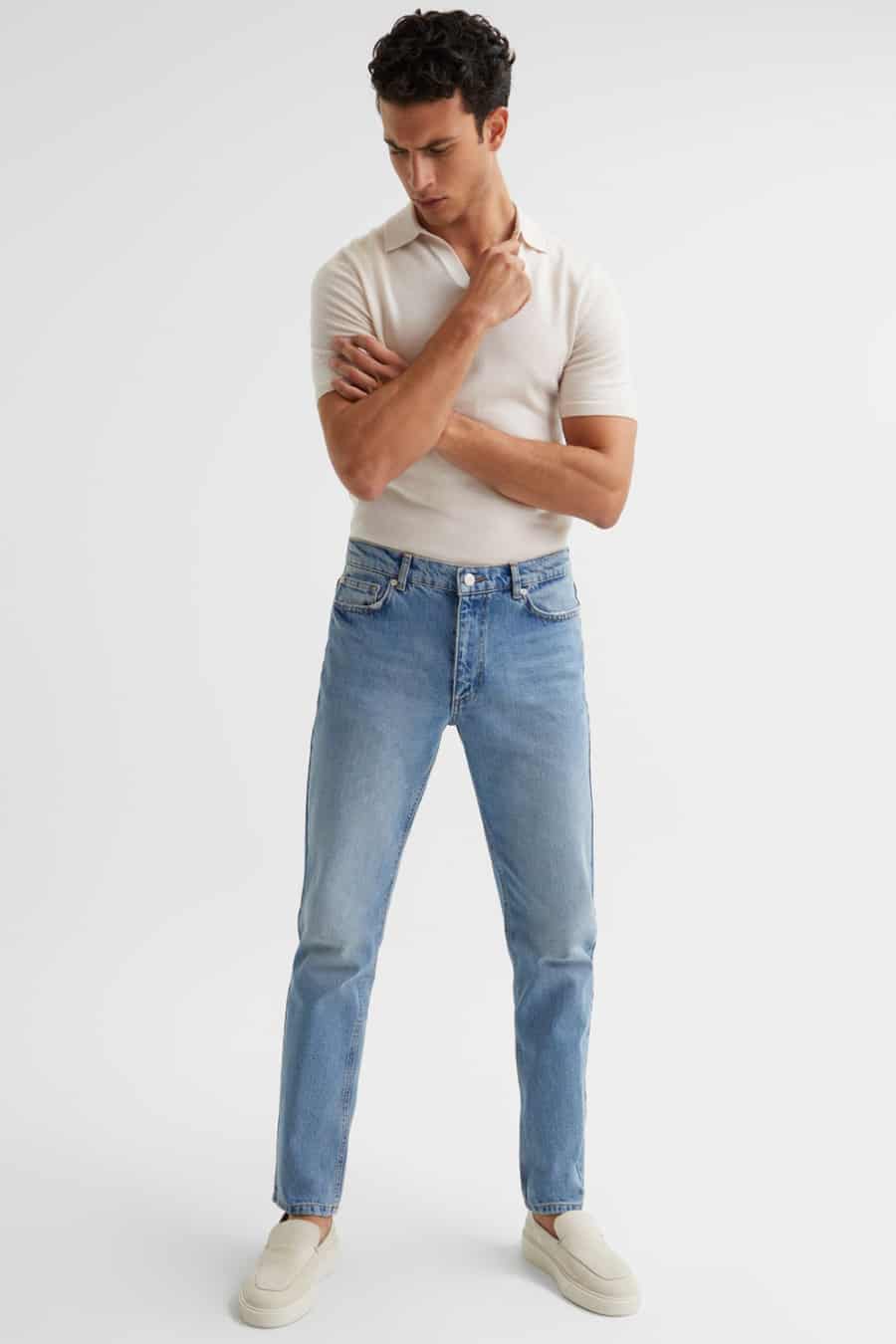 Men's light wash jeans, off-white knitted polo shirt and suede loafers outfit
