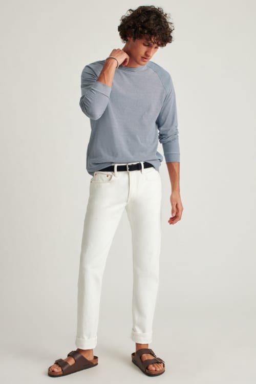 Men's white jeans, blue long sleeve top and brown leather sandals outfit