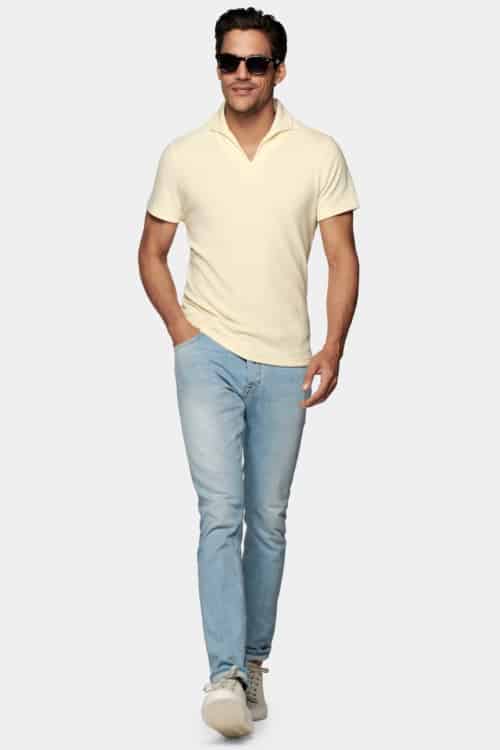 Men's light wash jeans, yellow polo shirt and suede sneakers outfit