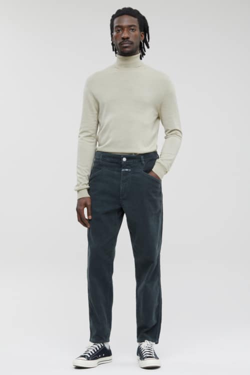 Men's navy chinos, off-white turtleneck and black canvas sneakers outfit