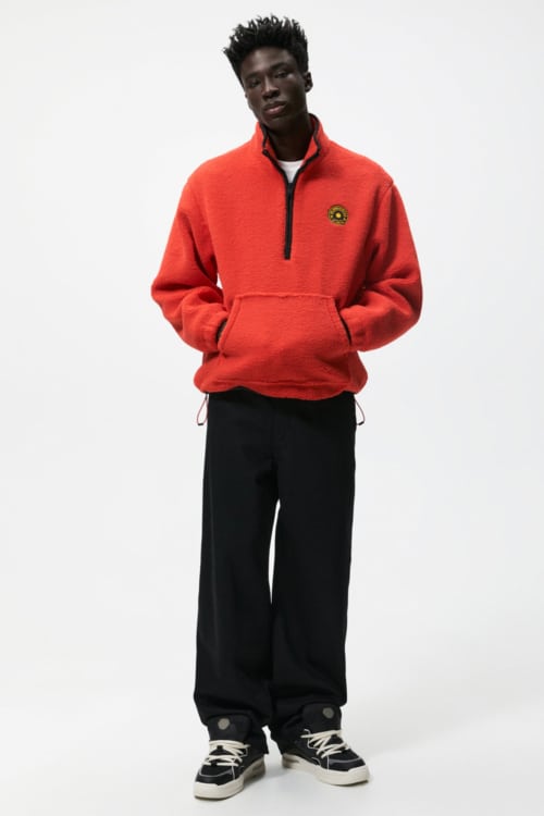 Men's wide black trousers, white T-shirt, bright red fleece and black chunky sneakers outfit