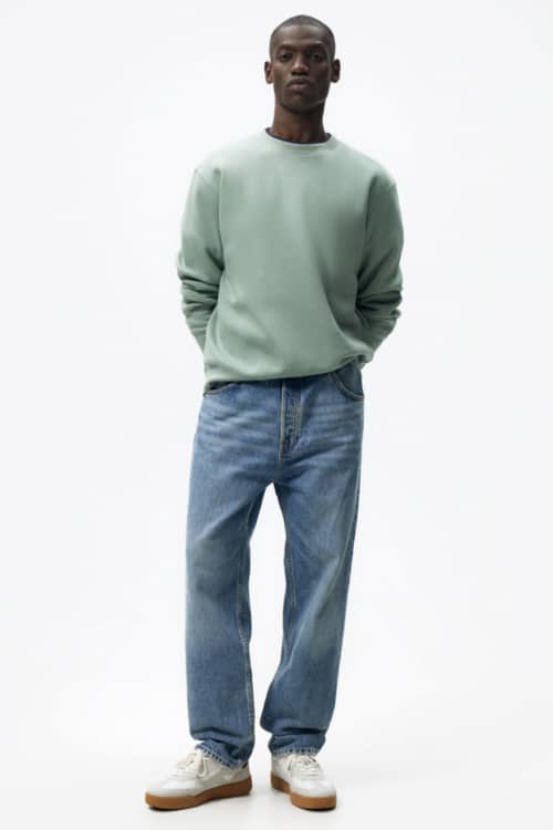 Men's light wash jeans, pale green sweatshirt and white sneakers outfit