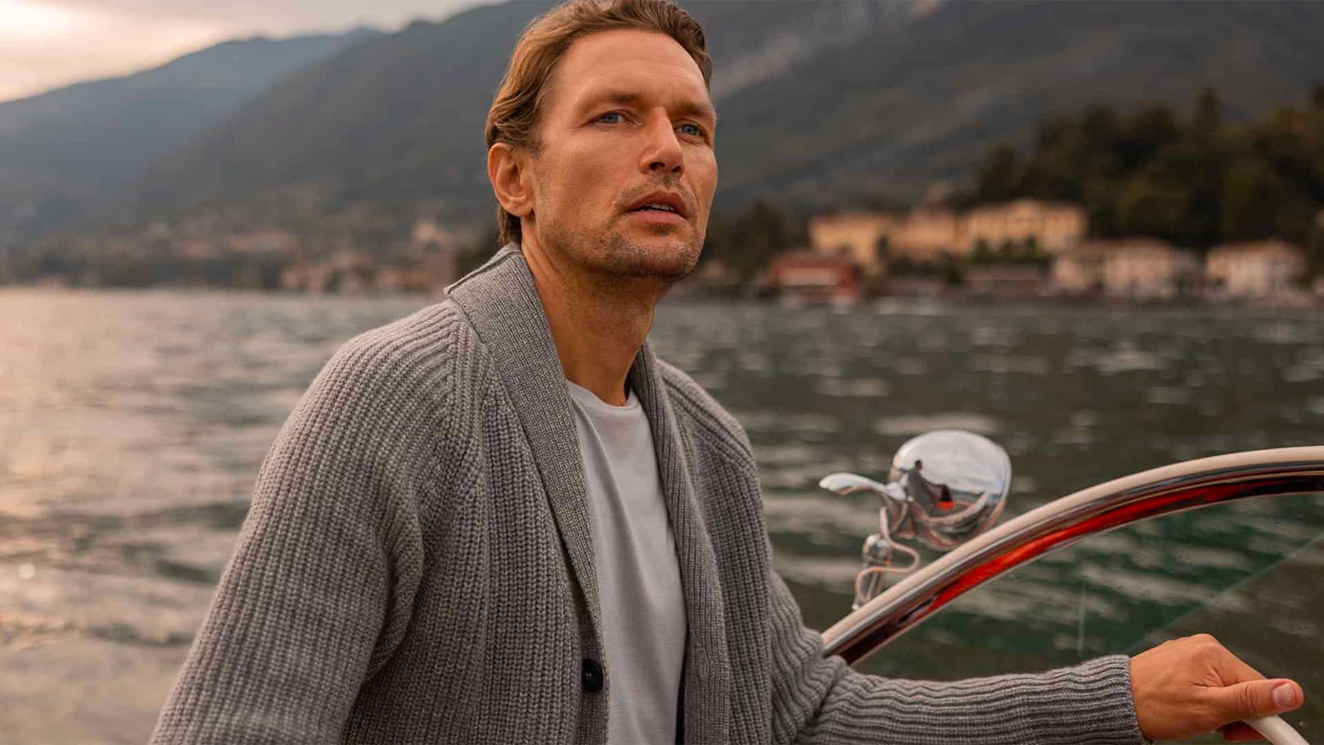 Man wearing grey ribbed shawl collar cardigan and white T-shirt on a boat