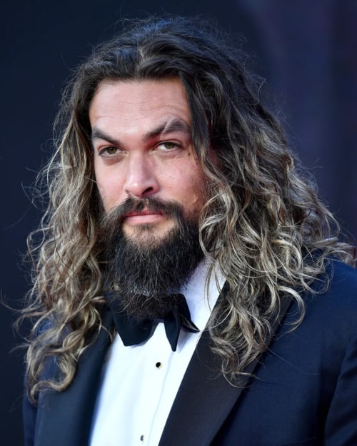 Man with long, natural curly/wavy hair with highlights