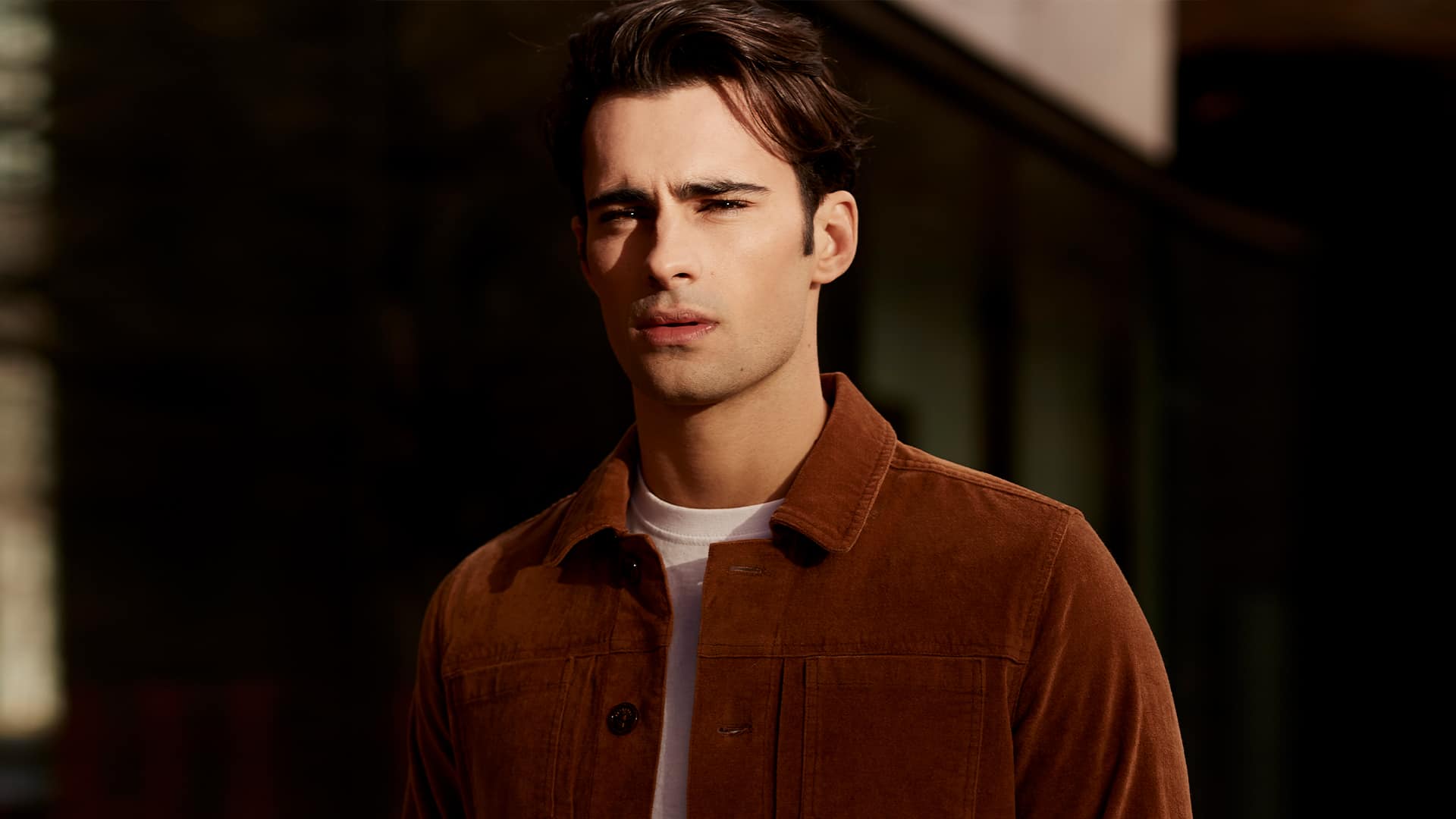 Man wearing white T-shirt and brown suede trucker jacket