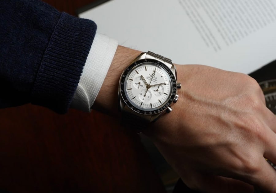 omega Speedmaster Moonwatch worn on wrist with white shirt and navy blazer