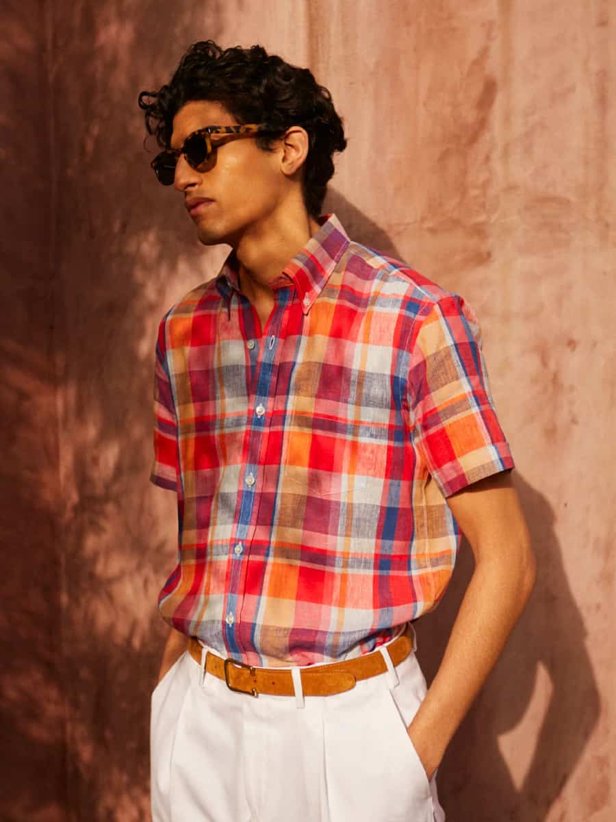Man wearing preppy short sleeve madras shirt and white trousers