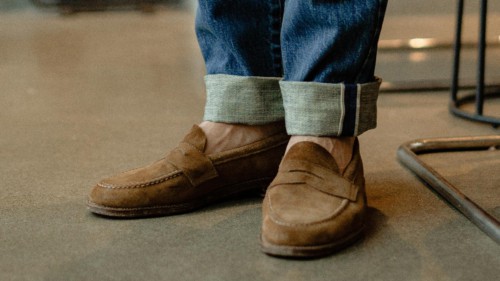 Man wearing mid-wash jeans and suede light brown loafers