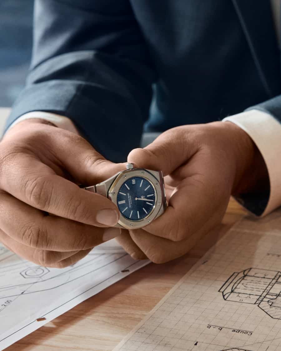 Man in suit holding a classic Audemars Piaget Royal Oak watch in his hands