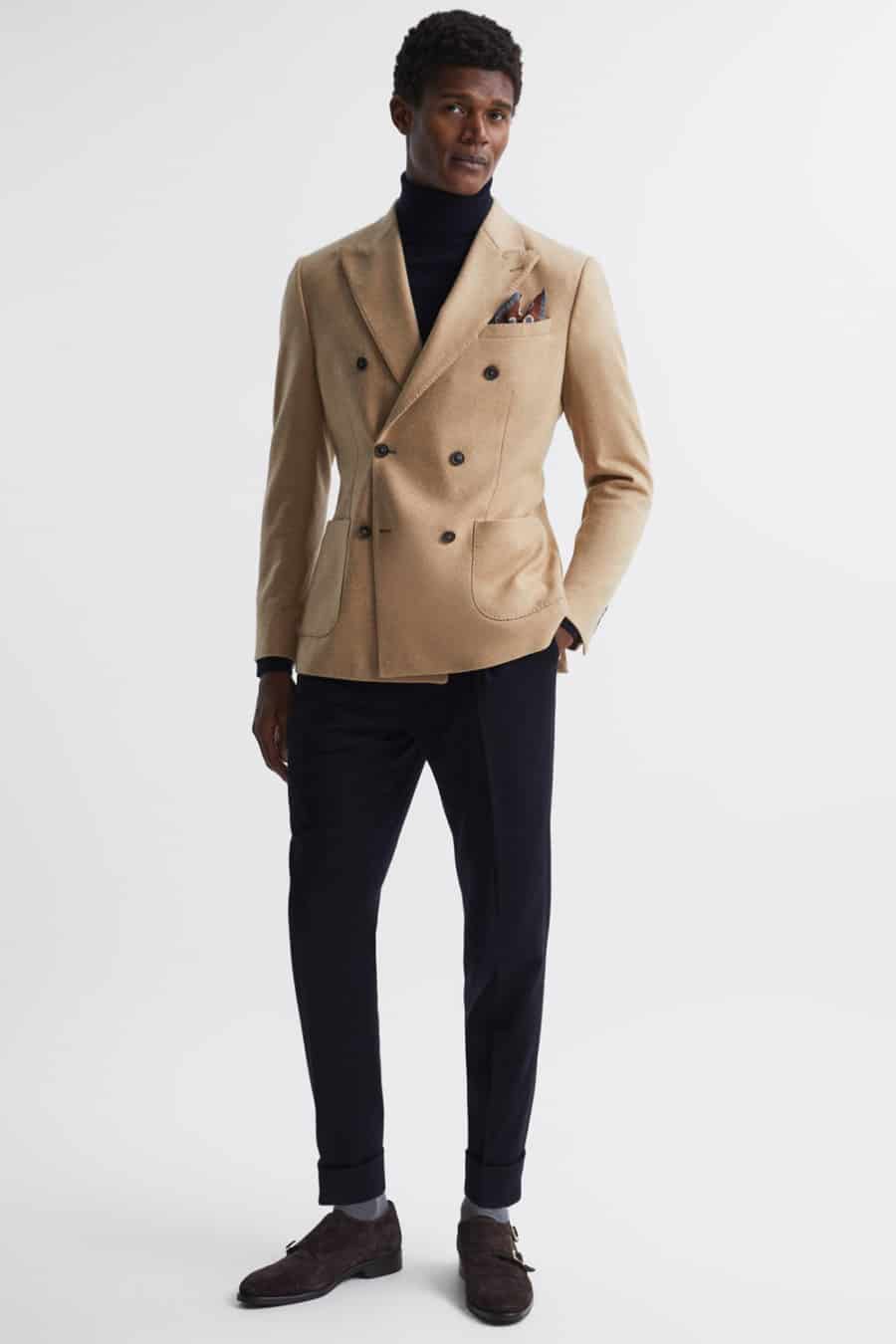 Men's black trousers, black roll neck, camel double breasted blazer and brown monk strap shoes outfit