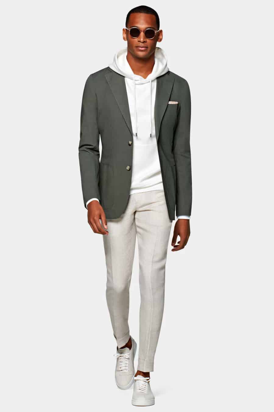 Men's grey trousers, white hoodie, green unstructured blazer and white sneakers outfit