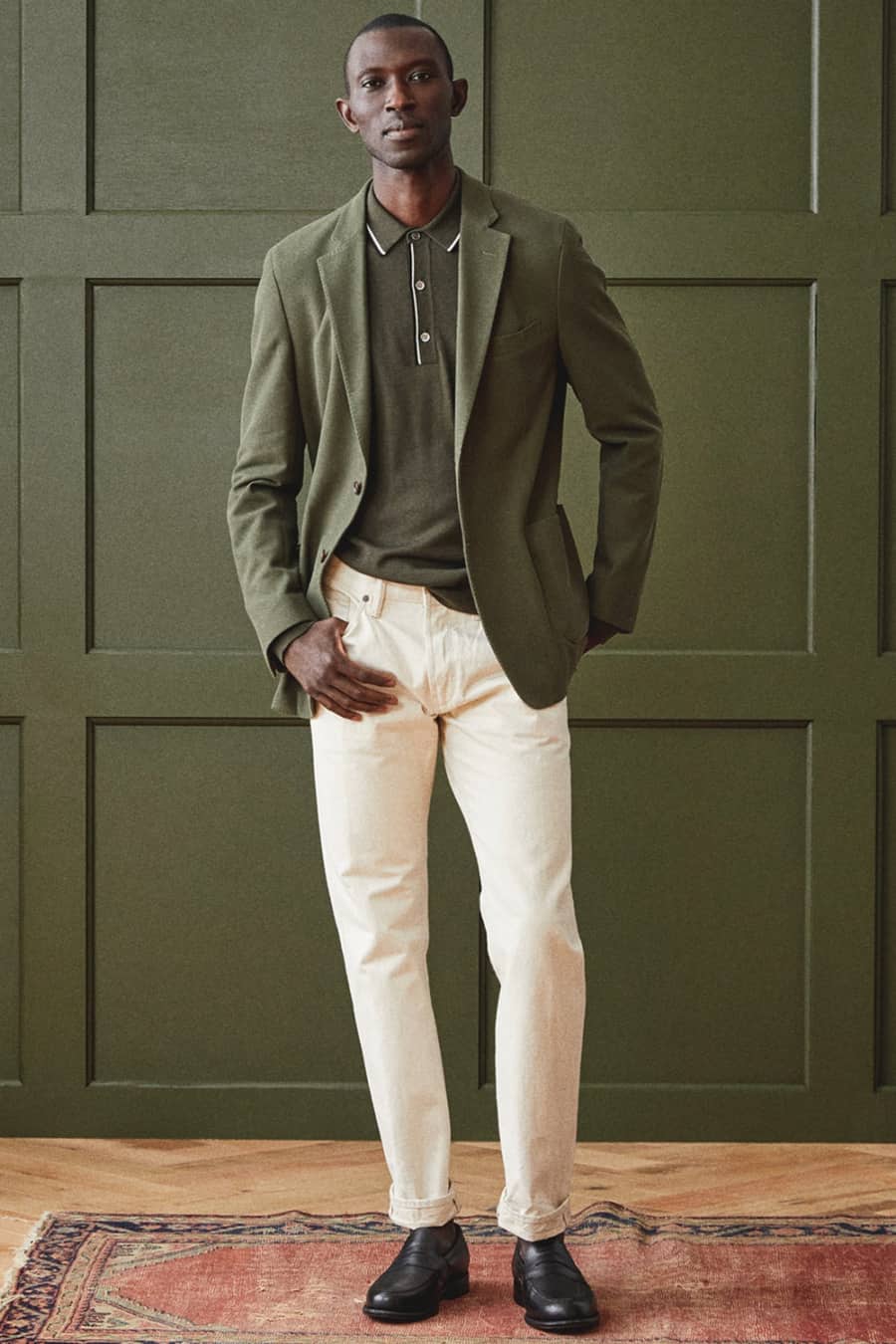 Men's white jeans, green polo shirt, green blazer and black loafers outfit
