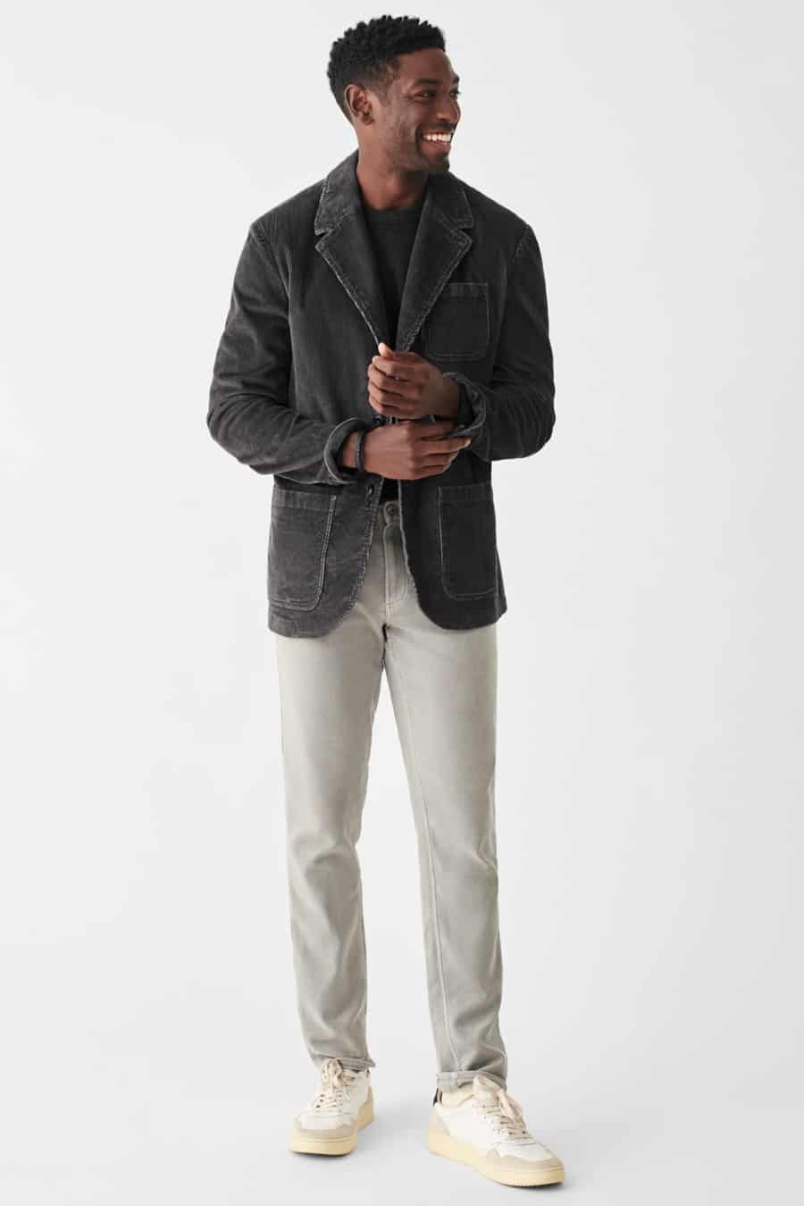 Men's grey jeans, washed black cotton blazer, black T-shirt and white sneakers outfit