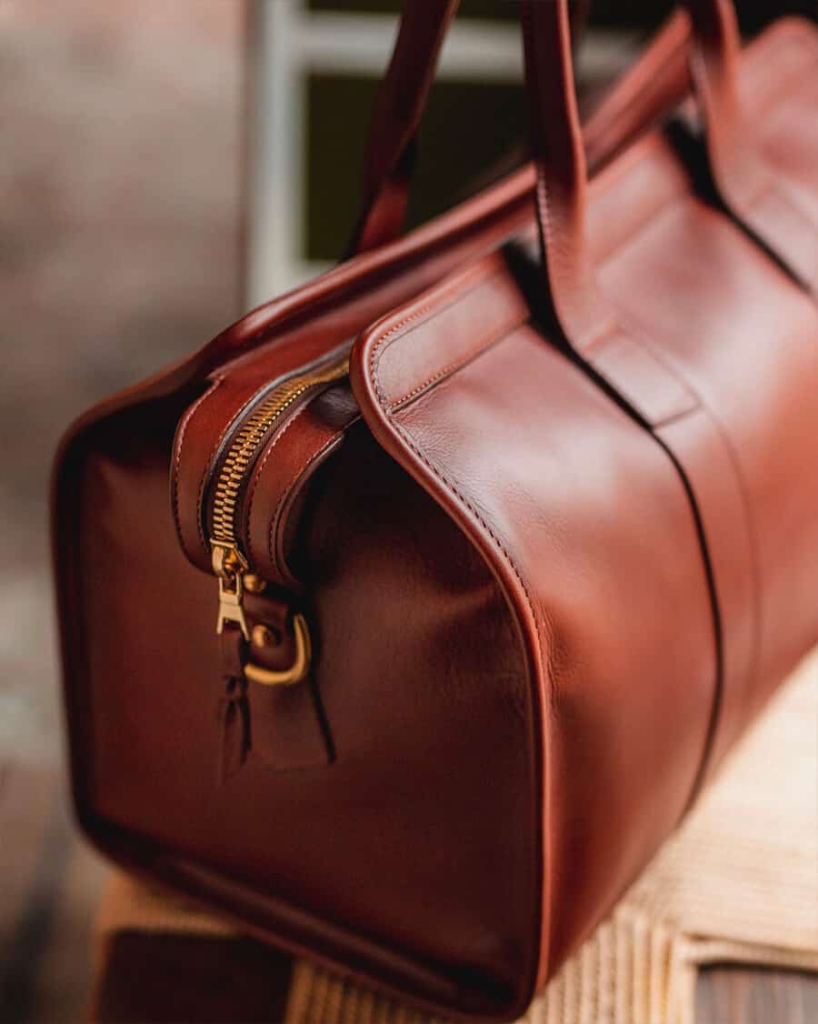 The end view of a tan leather men's luxury weekender bag
